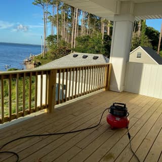 Covered porch and wood deck railing repainted, overlooking the waterfront