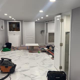 Lower-level remodel with new marble-look tile flooring, recessed lighting, and fresh paint